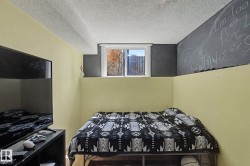 Recessed window providing natural light, textured ceiling, and a distinct chalkboard wall feature - 