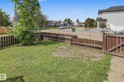 Gated yard area featuring a combination of wood fencing and a concrete border - 
