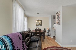 Hardwood-style flooring throughout the dining area and an overhead chandelier with multiple light sources - 