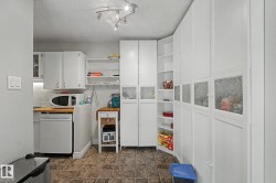 Compact kitchen area featuring white cabinetry, a wood-finish countertop, and integrated dishwasher - 
