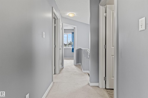 Upper-level hallway with light gray walls, white trim, and light-colored carpet flooring - 1154 35A Avenue Nw, Edmonton, AB - Indoor Photo Showing Other Room