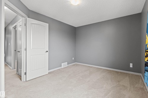 Carpeted room with neutral gray walls and white trim - 1154 35A Avenue Nw, Edmonton, AB - Indoor Photo Showing Other Room