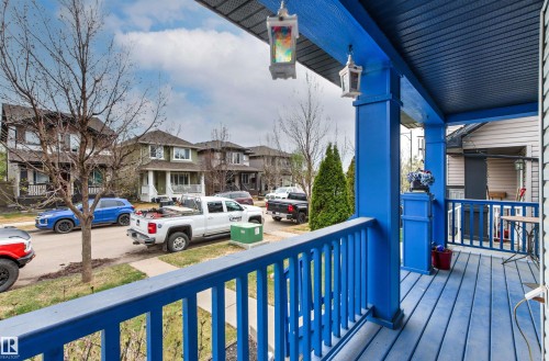 Covered front porch featuring a vibrant blue finish on the floorboards, railings, and support columns - 1154 35A Avenue Nw, Edmonton, AB - Outdoor With Deck Patio Veranda