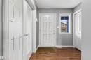 Entryway featuring a white paneled front door, wood-finish flooring, a rectangular window, and two closet doors - 1154 35A Avenue Nw, Edmonton, AB  - Indoor Photo Showing Other Room 