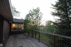 The large master bedroom easily supports king sized furniture, has a 3 piece ensuite, a walk in closet, and this private elevated deck, with an unimpeded view to into the ravine to the north - 