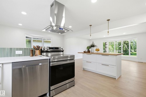 Modern kitchen featuring stainless steel appliances, a range hood, and a white countertop - 14335 47 Avenue Nw, Edmonton, AB - Indoor Photo Showing Kitchen