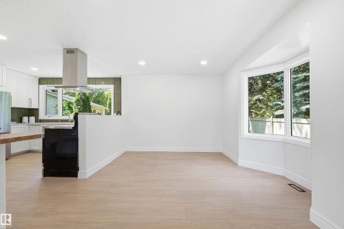 Open-concept living area with light wood-finish flooring, recessed lighting, and a bay window - 14335 47 Avenue Nw, Edmonton, AB - Indoor Photo Showing Kitchen