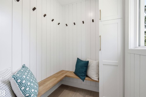 White vertical shiplap walls featuring an L-shaped wood-finish bench - 14335 47 Avenue Nw, Edmonton, AB - Indoor Photo Showing Other Room