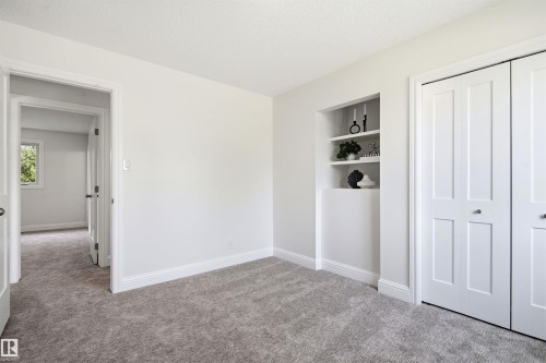Light grey carpeting throughout, crisp white walls, and bright white baseboards - 14335 47 Avenue Nw, Edmonton, AB - Indoor Photo Showing Other Room