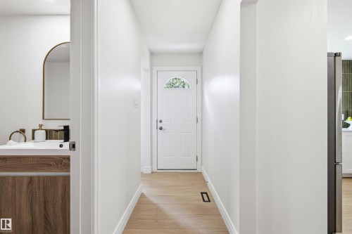 Entryway featuring light wood-finish flooring and a white front door with an arched window - 14335 47 Avenue Nw, Edmonton, AB - Indoor Photo Showing Other Room