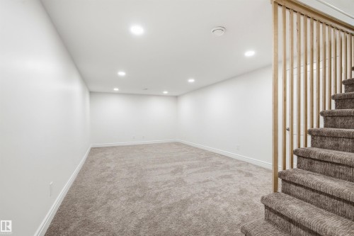 Spacious room featuring neutral carpeting, recessed lighting, and white baseboards - 14335 47 Avenue Nw, Edmonton, AB - Indoor Photo Showing Other Room