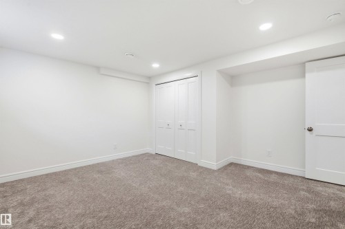 Neutral tone carpet flooring and white painted walls create a versatile interior - 14335 47 Avenue Nw, Edmonton, AB - Indoor Photo Showing Other Room