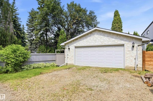Detached garage featuring a white panel door and textured exterior finish - 14335 47 Avenue Nw, Edmonton, AB - Outdoor