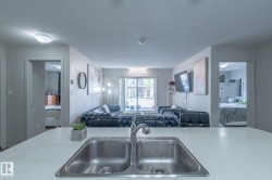 Kitchen island with a double basin stainless steel sink and a stainless steel faucet - 