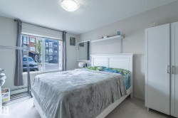 Bright room featuring a large window, soft neutral wall color, and light-toned carpet flooring - 