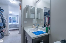 Bathroom vanity featuring a white sink, light-colored countertop, and dark wood-finish cabinetry - 