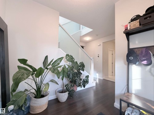 Entryway featuring dark wood-finish flooring, a contemporary staircase with glass panel railing, and recessed ceiling lighting - 5876 168 Avenue Nw, Edmonton, AB - Indoor Photo Showing Other Room