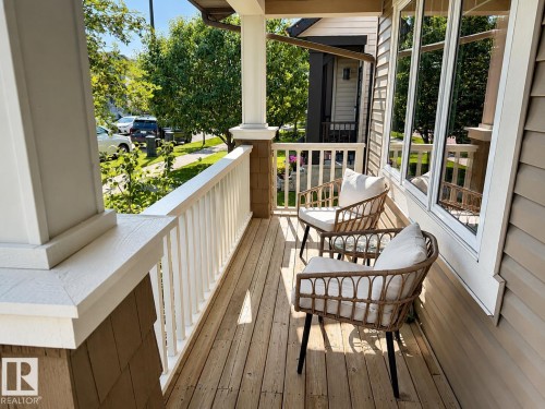 Inviting front porch featuring wood flooring, white railing, and shake siding accents - 3457 Cutler Crescent Sw, Edmonton, AB - Outdoor With Deck Patio Veranda With Exterior