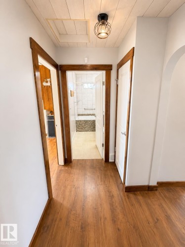 Hallway featuring wood-finish flooring, white walls, and dark wood trim - 610 8 Avenue, Wainwright, AB - Indoor Photo Showing Other Room