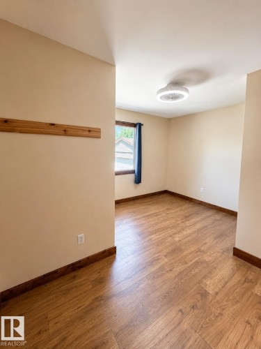 Neutral tone walls with wood-finish flooring throughout - 610 8 Avenue, Wainwright, AB - Indoor Photo Showing Other Room