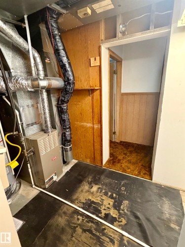 Utility area featuring a furnace system, exposed ductwork, and concrete flooring - 610 8 Avenue, Wainwright, AB - Indoor Photo Showing Other Room
