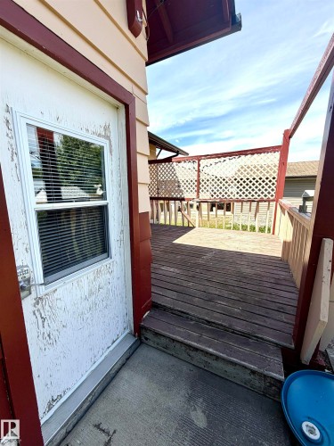 Exterior access point opening onto a wooden deck - 610 8 Avenue, Wainwright, AB - Outdoor With Exterior