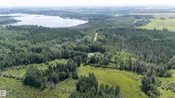 Expansive natural landscape featuring a prominent lake and dense forested areas - 