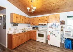 Kitchen featuring wood-finish cabinetry, wood-finish ceiling, and durable wood-finish flooring - 