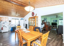 Vaulted wood-paneled ceiling with an overhead light fixture and ceiling fan - 