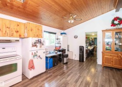 Kitchen space featuring wood-finish flooring, a vaulted wood-paneled ceiling, and recessed lighting - 