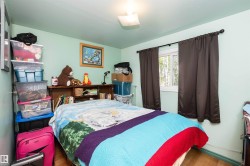 Inviting room featuring a window with dark drapes, wood-finish flooring, and a light-toned ceiling - 