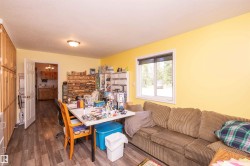 Spacious room featuring wood-finish flooring, a white-framed window, and a white interior door - 