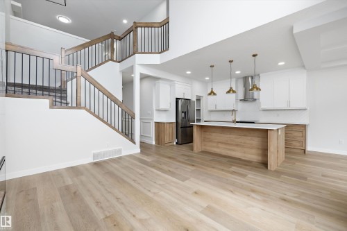Open-concept living space featuring wood-finish flooring throughout - 919 Elderberry Landing Nw, Edmonton, AB - Indoor Photo Showing Kitchen