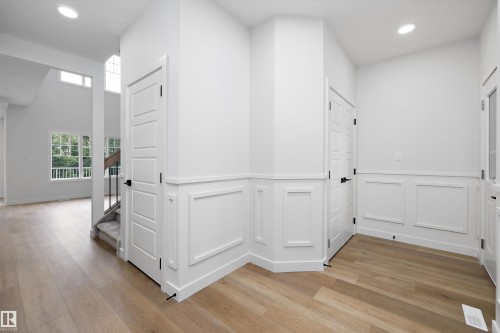 Foyer featuring light wood-finish flooring, white paneling, and recessed lighting - 919 Elderberry Landing Nw, Edmonton, AB - Indoor Photo Showing Other Room