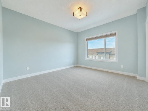 Light blue walls with white trim and neutral carpeting - #56 804 Welsh Dr Sw, Edmonton, AB - Indoor Photo Showing Other Room