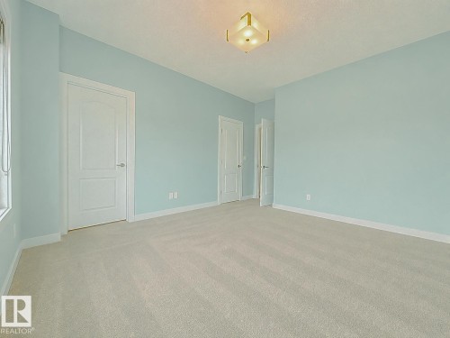 Spacious room with light blue walls and plush, light-colored carpeting - #56 804 Welsh Dr Sw, Edmonton, AB - Indoor Photo Showing Other Room