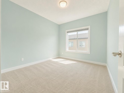 Bright interior space with light blue walls and a neutral carpet - #56 804 Welsh Dr Sw, Edmonton, AB - Indoor Photo Showing Other Room