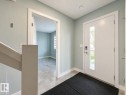 Entryway featuring a white door with a vertical glass insert, smart lock hardware, light blue-grey wall paint, and white trim - #56 804 Welsh Dr Sw, Edmonton, AB  - Indoor Photo Showing Other Room 