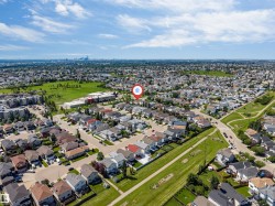 Aerial view of a residential neighborhood with detached homes, green spaces, and community infrastructure - 