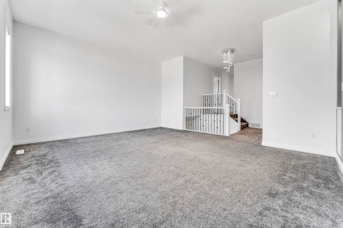 Spacious interior room featuring plush gray carpeting, white painted walls, and a ceiling fan with integrated lighting - 16205 55 Street Nw, Edmonton, AB - Indoor Photo Showing Other Room