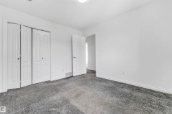 Spacious room featuring neutral grey carpet flooring and white painted walls - 