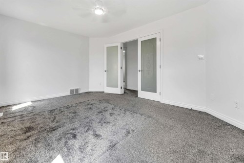Spacious room featuring neutral carpeting and white painted walls - 16205 55 Street Nw, Edmonton, AB - Indoor Photo Showing Other Room