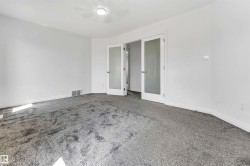 Spacious room featuring neutral carpeting and white painted walls - 