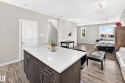 Kitchen island with white countertop, dark wood-finish cabinetry, and stainless steel hardware - 