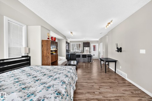 Open-concept living space featuring wood-finish flooring throughout - #10 2803 James Mowatt Trail Sw, Edmonton, AB - Indoor