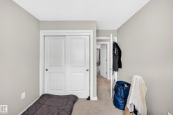Bedroom featuring a sliding double-door closet, neutral-toned walls, and carpet flooring - 
