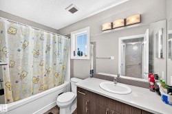 Bathroom featuring a white bathtub, toilet, and a vanity with an integrated sink - 