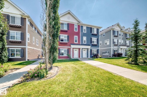 Row of multi-level townhomes featuring distinct siding colors and white trim - #10 2803 James Mowatt Trail Sw, Edmonton, AB - Outdoor With Balcony With Facade