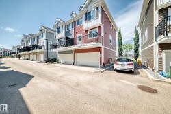 Row of contemporary townhomes featuring multiple individual garages, private balconies with black railings, and gabled rooflines - 