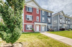 Three-story townhome exterior featuring red and blue siding, white window frames, dark shutters, and decorative window boxes - 